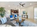 Bright living room with gray sofa and blue armchairs, coffee table, and ceiling fan at 6565 E Thomas Rd # 1005, Scottsdale, AZ 85251