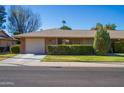 House with a beige exterior, attached garage, and neat landscaping at 9614 N 110Th Ave, Sun City, AZ 85351