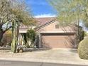 Single-story home with a brown garage door, landscaped yard with cacti, and a tile roof at 15720 E Yucca Dr, Fountain Hills, AZ 85268