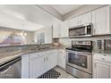 Modern kitchen with white cabinets, granite counters, and stainless steel appliances at 1976 S 172Nd Ln, Goodyear, AZ 85338