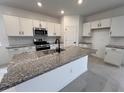 Modern kitchen with white cabinets, granite countertops, stainless steel appliances, and a large center island at 20629 N 226Th Ln, Surprise, AZ 85387