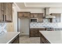 Open-concept kitchen boasts stainless steel appliances, wooden cabinets, patterned backsplash, and large island at 24235 N 194Th Ave, Surprise, AZ 85387