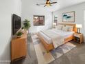 Bright bedroom with a large bed, dresser, and flat-screen TV at 3305 S 122Nd Ln, Tolleson, AZ 85353