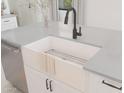 Farmhouse sink with a black gooseneck faucet and grey countertop at 4380 N 203Rd Dr, Buckeye, AZ 85396