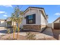 Side exterior view of the home showing stone accents and tasteful landscaping at 4419 N 203Rd Ave, Buckeye, AZ 85396