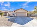 Tan house with a two-car garage and landscaped front yard at 44611 W Mescal St, Maricopa, AZ 85138