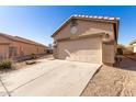View of the home's garage and driveway, with desert landscaping at 1102 N 5Th St, Buckeye, AZ 85326