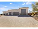 Modern three-car garage home with paver driveway and desert landscaping at 14327 E Skinner Dr, Scottsdale, AZ 85262