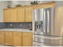 Kitchen with wood cabinets, granite counters, and stainless steel fridge at 14335 W Country Gables Dr, Surprise, AZ 85379