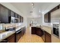 Spacious kitchen featuring granite countertops and dark wood cabinets at 17606 N 17Th Pl # 1021, Phoenix, AZ 85022