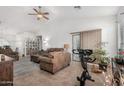 Living room with tiled floors, brown couches, and patio access at 18208 W Skyline Dr, Surprise, AZ 85374