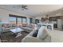 Open living room showcasing a cozy sectional sofa and large windows at 24271 N 194Th Ave, Surprise, AZ 85387