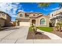 Two-story house with a tan facade, arched windows, and a three-car garage at 2838 E Shady Spring Trl, Phoenix, AZ 85024