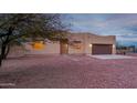 Tan stucco house with brown garage door, stone pathway, and gravel yard at 38913 N 21St Ave, Phoenix, AZ 85086