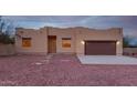 Tan stucco house with brown garage door, and gravel yard at 38913 N 21St Ave, Phoenix, AZ 85086