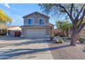 Two-story house with a beige exterior, two-car garage, and desert landscaping at 4529 E Coyote Wash Dr, Cave Creek, AZ 85331