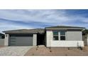 Charming single-story home featuring a gray facade, a gray garage door, and simple landscaping at 7638 W Rowel Rd, Peoria, AZ 85383