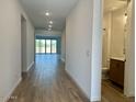 Bright hallway with wood-look tile flooring, recessed lighting, and a view of the living area at 7638 W Rowel Rd, Peoria, AZ 85383