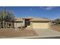 One-story house with a tan exterior, tile roof, and desert landscaping featuring a large cactus at 9020 E Brittle Bush Rd, Gold Canyon, AZ 85118