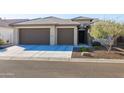 Two-car garage and front entrance of home with desert landscaping at 16925 W Virginia Ave, Goodyear, AZ 85395