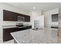 Modern kitchen features granite countertops and dark wood cabinets at 1779 W Spaulding Ave, Apache Junction, AZ 85120
