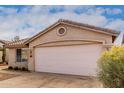 Tan house with a two-car garage and yellow flowers at 3041 E Wahalla Ln, Phoenix, AZ 85050