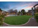 Landscaped backyard featuring a pool, playset, and putting green at 3457 E Virgil Dr, Gilbert, AZ 85298