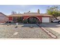 Red brick ranch style home with a landscaped front yard and a two-car garage at 6433 W Cortez St, Glendale, AZ 85304