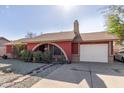 Red brick ranch home with a landscaped front yard and a two-car garage at 6433 W Cortez St, Glendale, AZ 85304