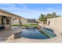 Inviting backyard pool with a large grassy area and covered patio at 10302 E Dolphin Ave, Mesa, AZ 85208