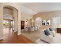 Bright dining room with a large table, chairs, chandelier, wood flooring, and arched entryway at 10626 E Voax Dr, Sun Lakes, AZ 85248