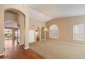 Bright living room showcasing arched doorways and a large window with plantation shutters at 10626 E Voax Dr, Sun Lakes, AZ 85248