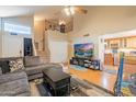 Spacious living room with hardwood floors, a sectional sofa, and views into the kitchen at 11618 W Olive Dr, Avondale, AZ 85392