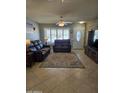 Spacious living room featuring tiled floors, comfy leather furniture, and a large window at 12411 N Cantata Ct, Sun City, AZ 85351