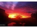 Backyard view of fiery sunset reflecting in the pool at 17844 E Pacana Ct, Gold Canyon, AZ 85118