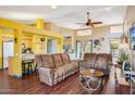 Cozy living room with high ceilings, hardwood floors, ceiling fan, and seamless access to the kitchen at 1801 E Aire Libre Ave, Phoenix, AZ 85022