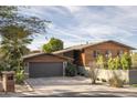 House exterior showcasing a modern design with wood siding and a two-car garage at 2235 E Vista Ave, Phoenix, AZ 85020