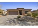 Single-story home with brown exterior, stone accents, and a two-car garage at 27121 N 84Th Dr, Peoria, AZ 85383