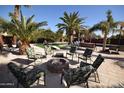 Outdoor entertainment space featuring a cozy fire pit surrounded by comfortable seating and a lush green lawn at 31689 N Blackfoot Dr, San Tan Valley, AZ 85143