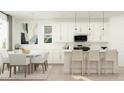 Modern kitchen with island, white cabinets, and dining area at 3344 S Channing Cir, Mesa, AZ 85212