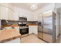 Galley kitchen with stainless steel appliances and wood countertops at 3491 N Arizona Ave # 54, Chandler, AZ 85225