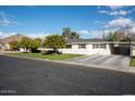 White single story home with a tree-lined front yard, driveway, and basketball hoop at 3601 N 48Th Way, Phoenix, AZ 85018