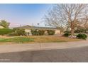 Ranch style home with grassy front yard and mature trees at 6627 N 16Th Dr, Phoenix, AZ 85015