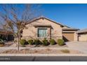 Tan house with stone accents, landscaping, and a two-car garage at 10434 E Texas Ave, Mesa, AZ 85212