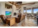 Spacious living room with a large fireplace and leather seating at 11105 E Tamarisk Way, Scottsdale, AZ 85262