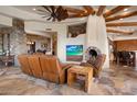 Open living room with stone fireplace and large windows at 11105 E Tamarisk Way, Scottsdale, AZ 85262