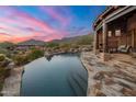 Stunning infinity pool with mountain views at sunset at 11105 E Tamarisk Way, Scottsdale, AZ 85262