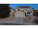 Two-story house with solar panels and a two-car garage at 11534 W Longley Ln, Youngtown, AZ 85363