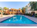 Community swimming pool with plenty of lounge chairs for relaxation at 14575 W Mountain View Blvd # 12303, Surprise, AZ 85374