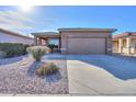 Light brown house with a two-car garage and nicely landscaped yard at 1861 E Birch St, Casa Grande, AZ 85122